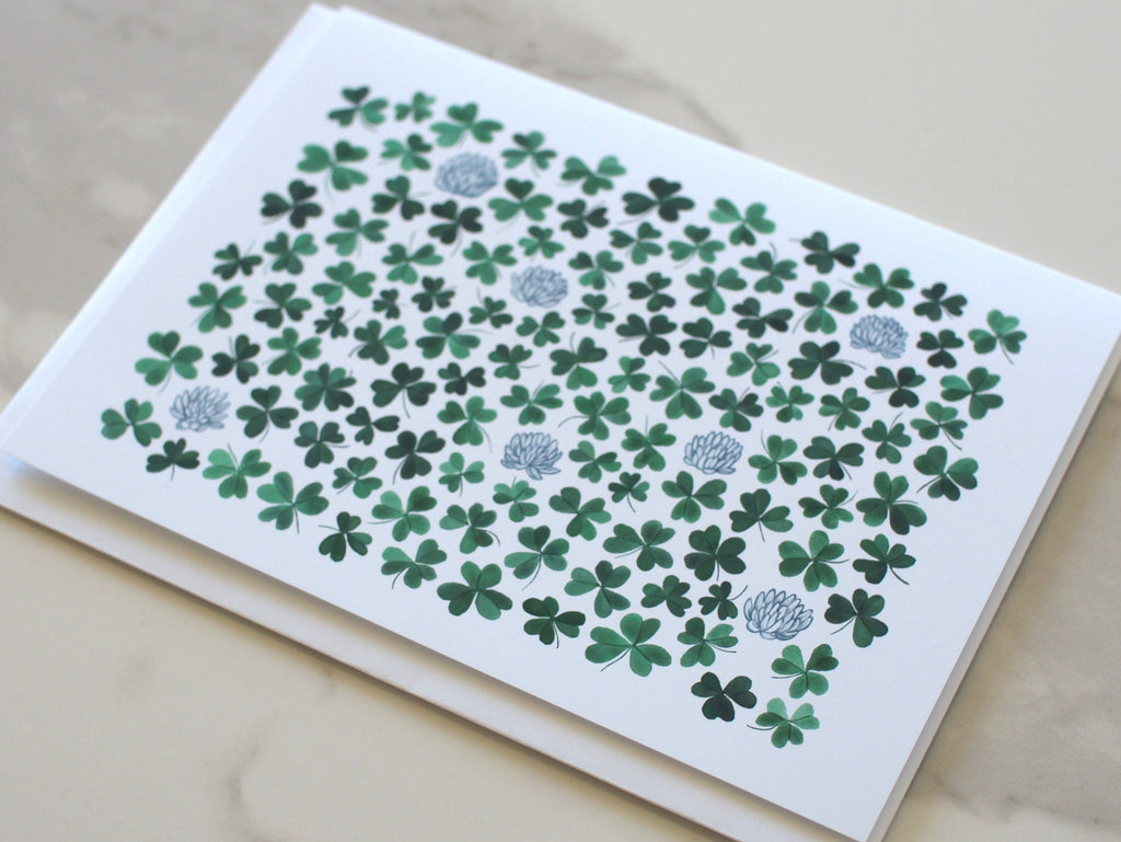 Greeting card with green leaf pattern on marble surface