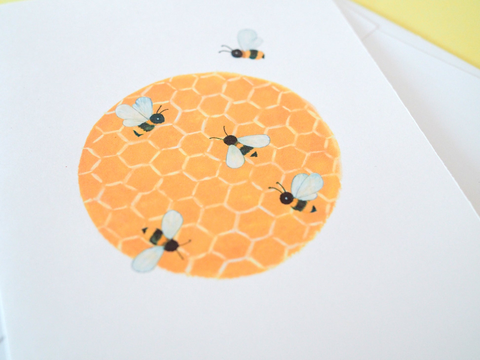 Round orange honeycomb with bees on a white background