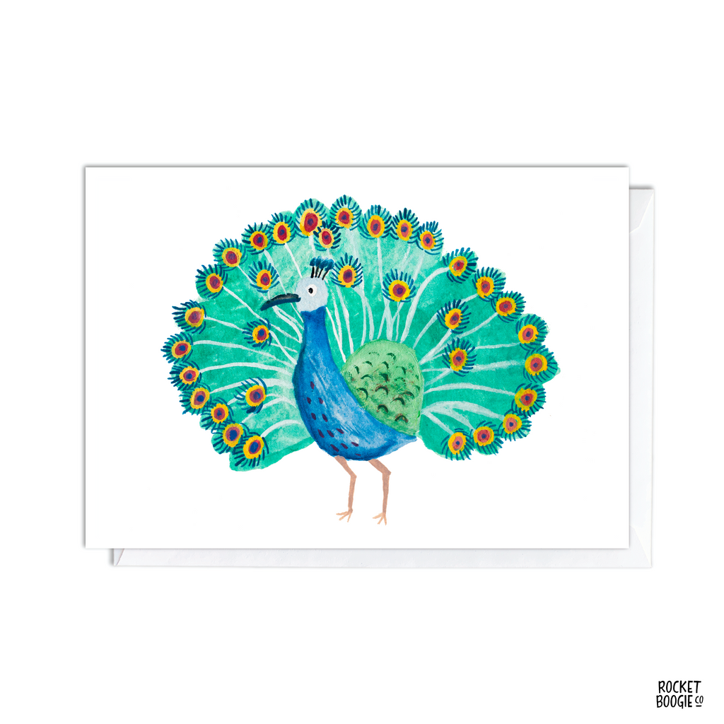 A greeting card featuring a colorful illustration of a peacock with an open tail displaying vibrant colors.
