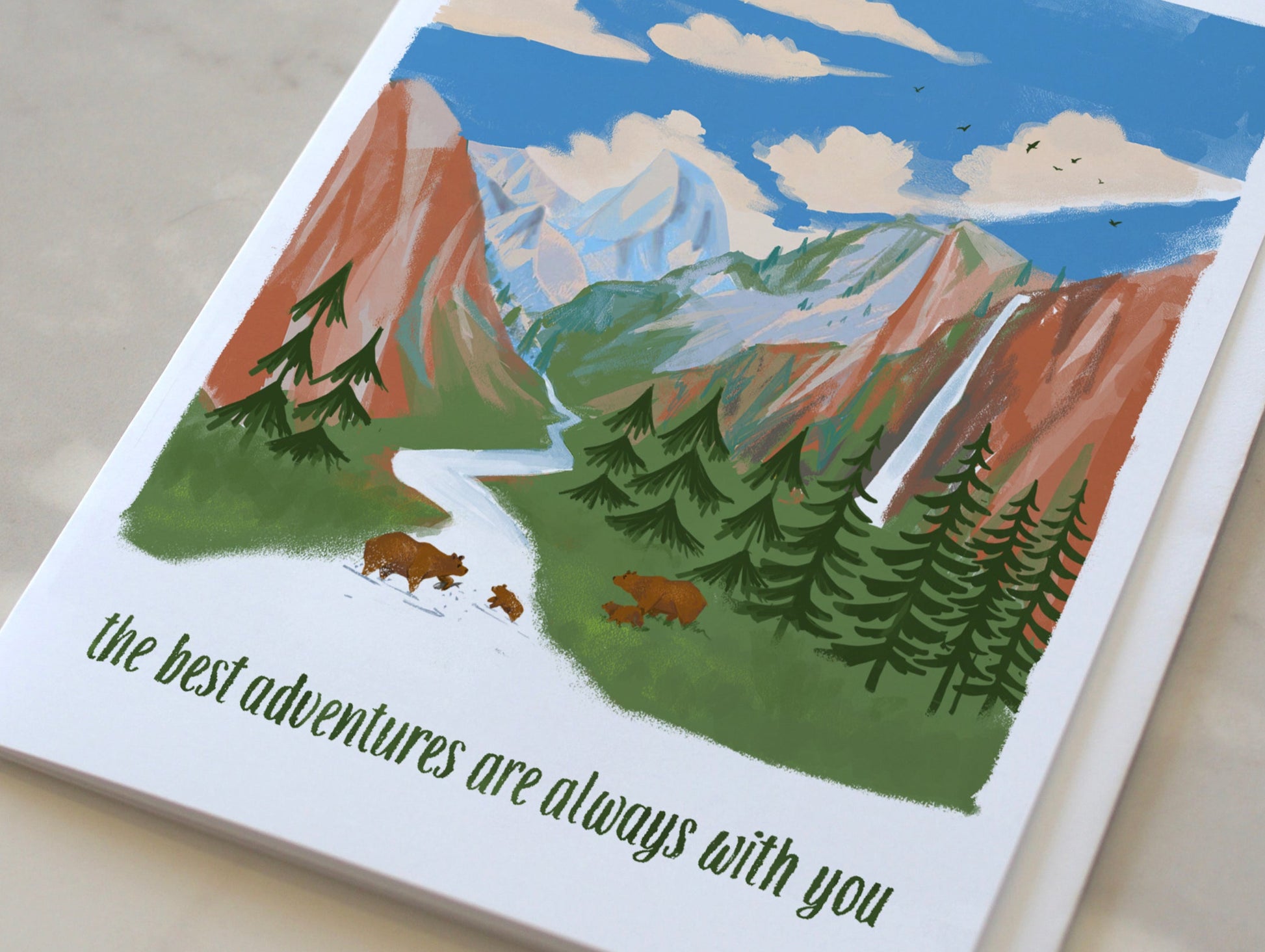 Card with mountain and bear illustration on a marble surface